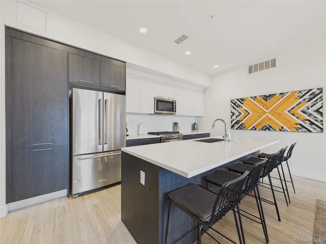 a kitchen with stainless steel appliances a stove a refrigerator and a refrigerator