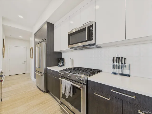 a kitchen with stainless steel appliances granite countertop a stove microwave and refrigerator