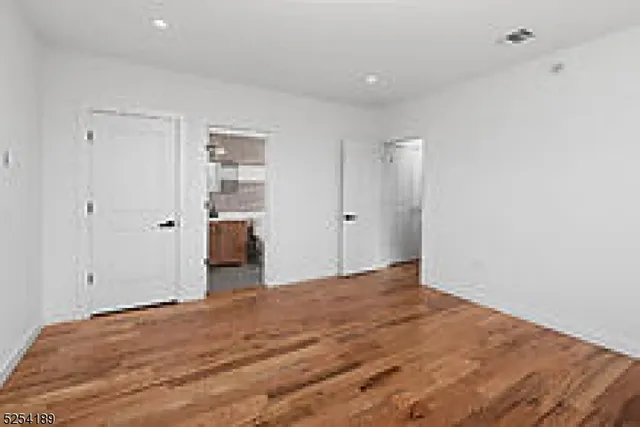 a view of empty room with wooden floor