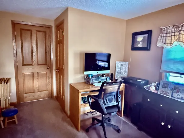 a view of a workspace with furniture and a window