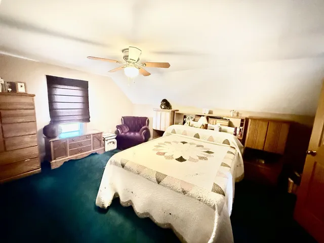 a bed sitting in a bedroom next to a window with a chandelier