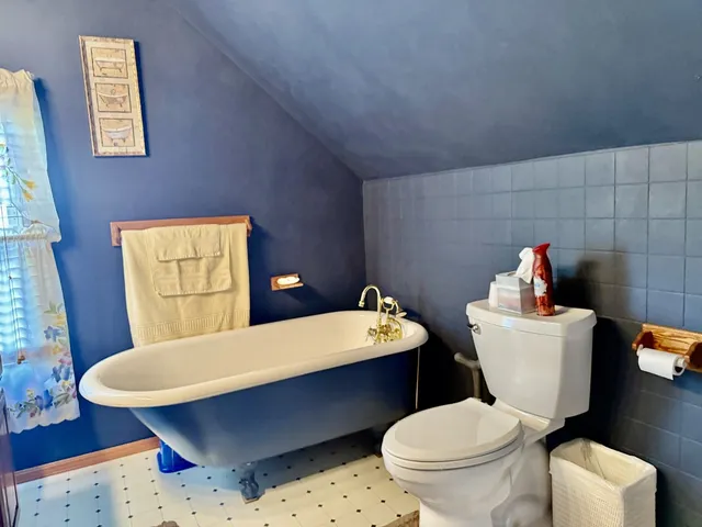 a white toilet sitting next to a bathroom sink and a mirror