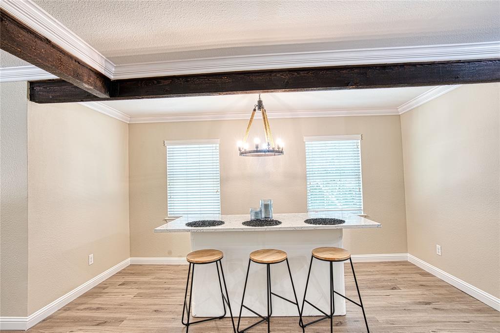 420 North Road Kennedale, TX 76060 - Photo 11 of 36 Unfurnished dining area with light wood finished floors, ornamental molding, a chandelier, and a textured wall