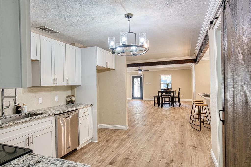 420 North Road Kennedale, TX 76060 - Photo 17 of 36 Kitchen featuring white cabinetry, a chandelier, decorative light fixtures, stainless steel dishwasher, and ornamental molding