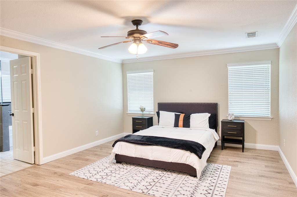 420 North Road Kennedale, TX 76060 - Photo 22 of 36 Bedroom featuring light wood-style floors, ornamental molding, ceiling fan, ensuite bath, and multiple windows