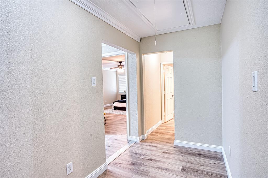 420 North Road Kennedale, TX 76060 - Photo 33 of 36 Hallway with attic access, a textured wall, and light wood-style flooring