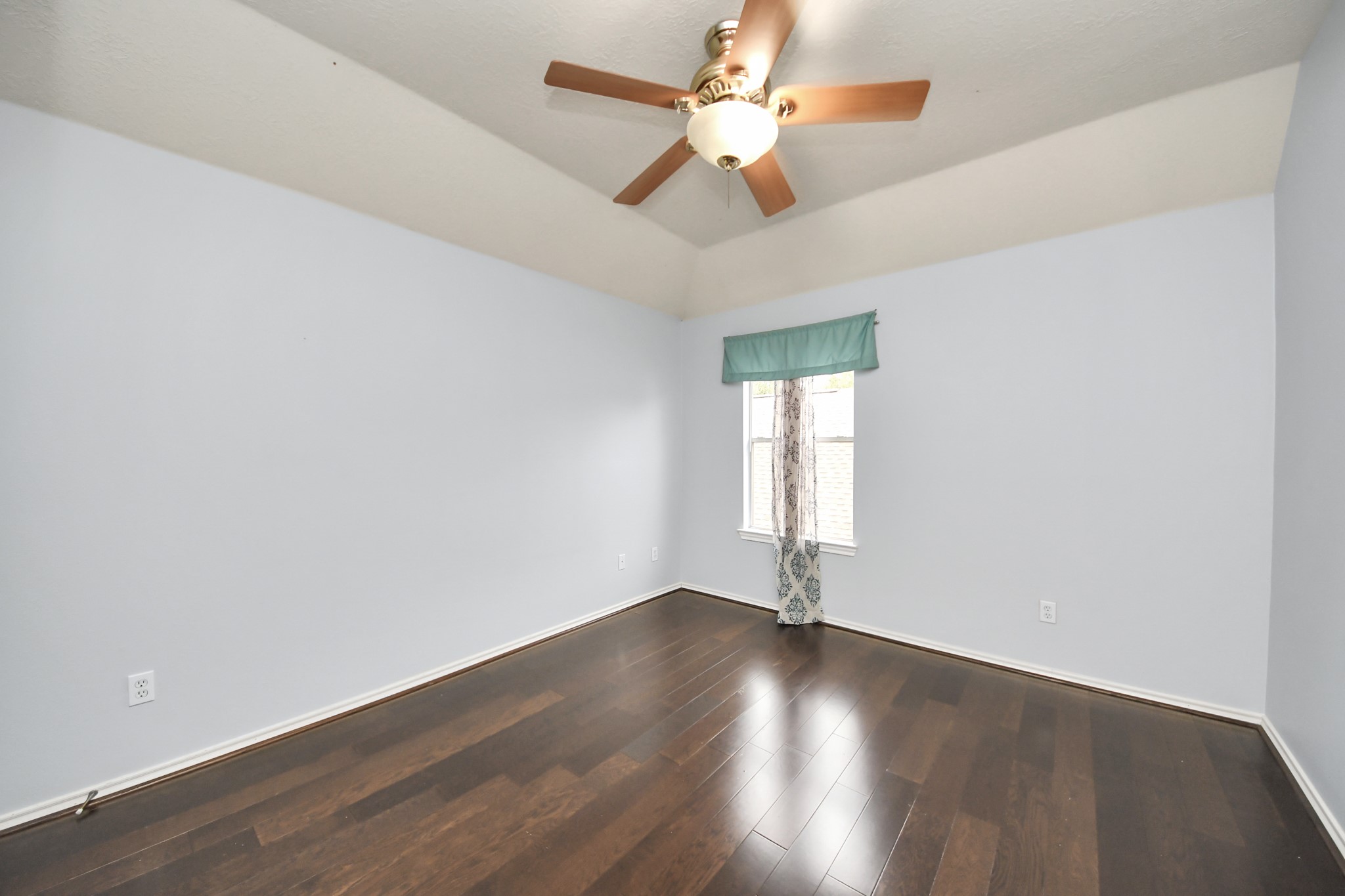 23906 Indian Crest Court Katy, TX 77494 - Photo 19 of 32 an empty room with wooden floor fan and windows