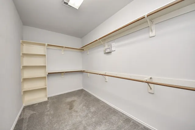 a view of walk in closet with empty racks