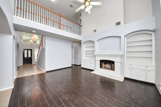 a view of a livingroom with an empty kitchen and a fireplace