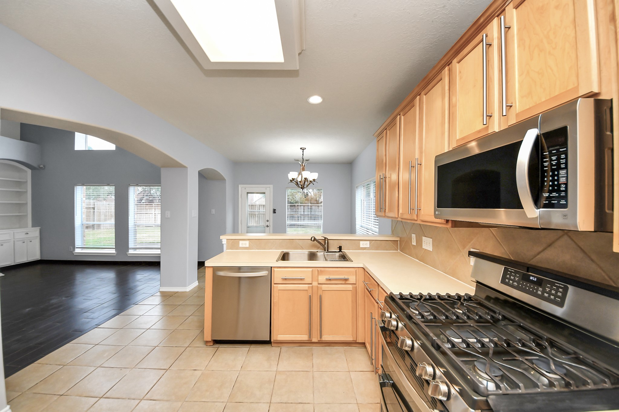 23906 Indian Crest Court Katy, TX 77494 - Photo 9 of 32 a kitchen with stainless steel appliances a stove a sink and a microwave