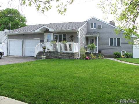 596 Foxhurst Road Baldwin, NY 11510 - Photo 1 of 1 a front view of a house with a garden and yard