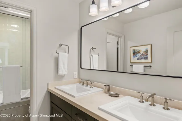 a bathroom with 2 sink and a mirror