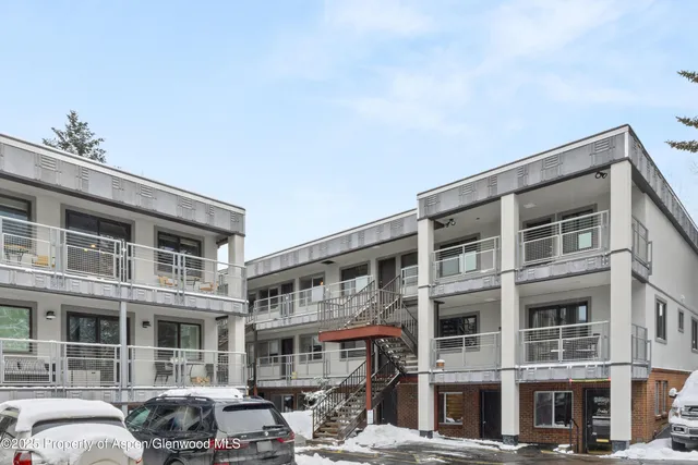 a front view of a building with lot of cars