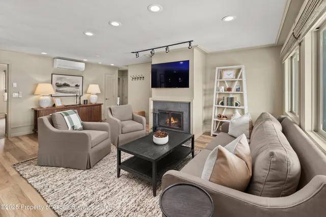 a living room with furniture a flat screen tv and a fireplace