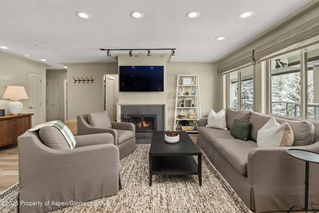 a living room with furniture a fireplace and a flat screen tv