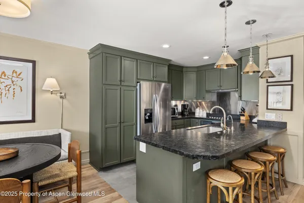 a kitchen with stainless steel appliances granite countertop a sink refrigerator and cabinets