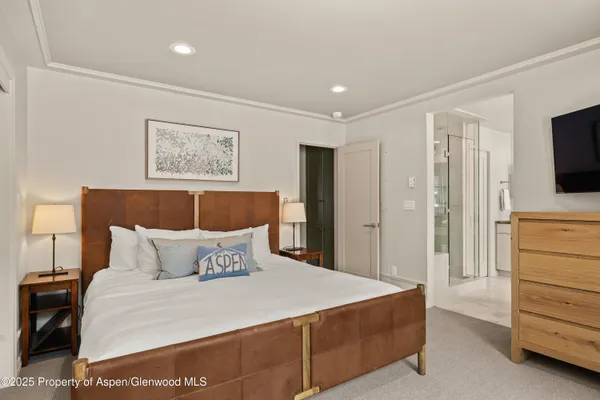 a bedroom with a bed and a flat screen tv