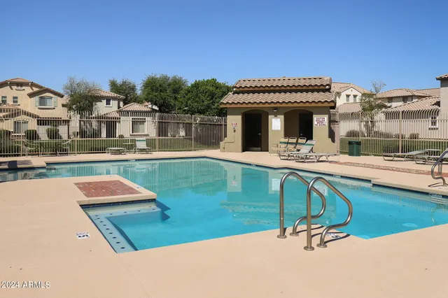 a view of a patio with lawn chairs wooden floor and fence