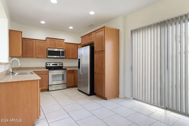a kitchen with kitchen island granite countertop cabinets and stainless steel appliances