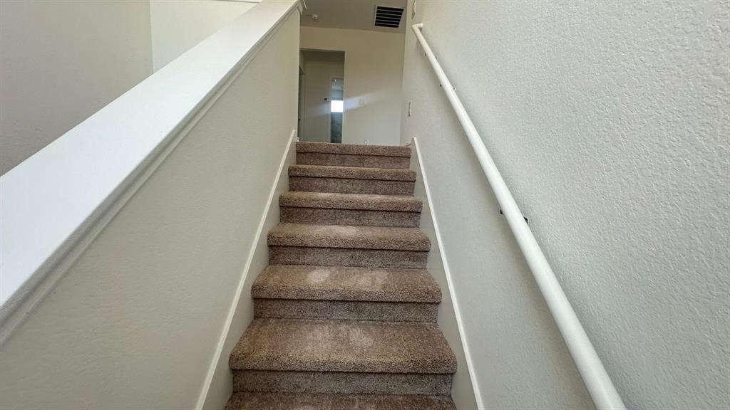 192 Rodney Boat Road Kyle, TX 78640 - Photo 15 of 38 Carpeted stairs ascend to an upper level, offering practical and quiet access.