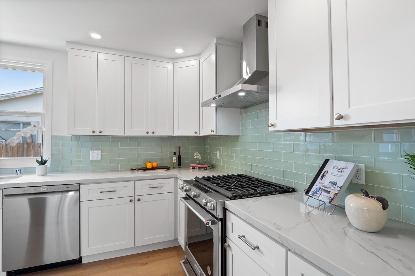 675 Linda Mar Boulevard Pacifica, CA 94044 - Photo 16 of 44 a kitchen with white cabinets and a stove top oven