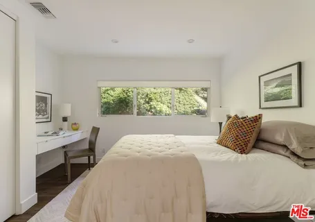 a bedroom with a large bed and a window