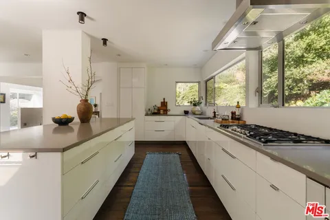 a kitchen with stainless steel appliances a sink a window and cabinets