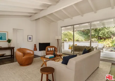 a living room with furniture and a floor to ceiling window