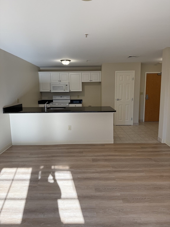 10 Florence Street, Unit 309 Malden, MA 02148 - Photo 2 of 15 a view of a kitchen with kitchen island wooden floor and stainless steel appliances