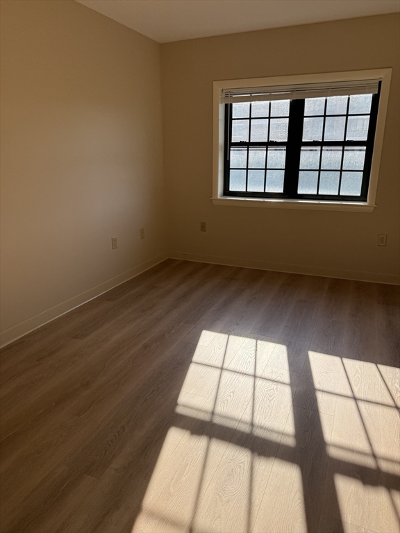 10 Florence Street, Unit 309 Malden, MA 02148 - Photo 5 of 15 an empty room with wooden floor and windows