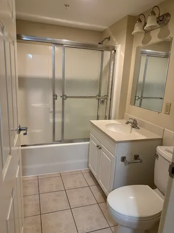 a bathroom with a sink a toilet a mirror and shower