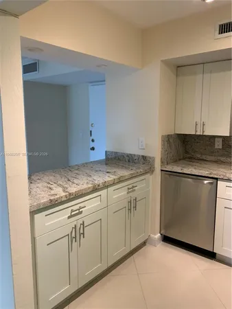 a kitchen with granite countertop white cabinets and white appliances
