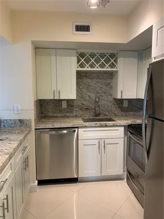 a kitchen with granite countertop stainless steel appliances and wooden cabinets