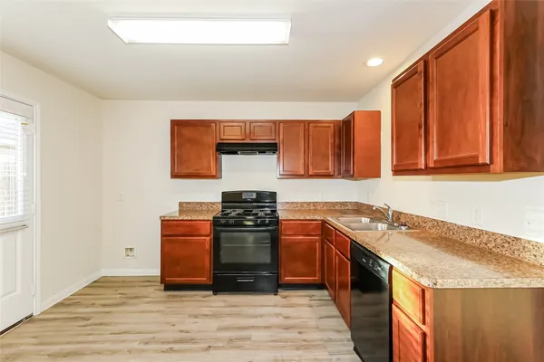 a kitchen with stainless steel appliances granite countertop a stove a sink and a microwave