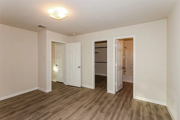 a view of empty room with wooden floor