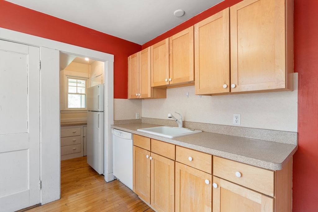 9 Searle Avenue Brookline, MA 02445 - Photo 16 of 35 a kitchen with a sink cabinets and a window