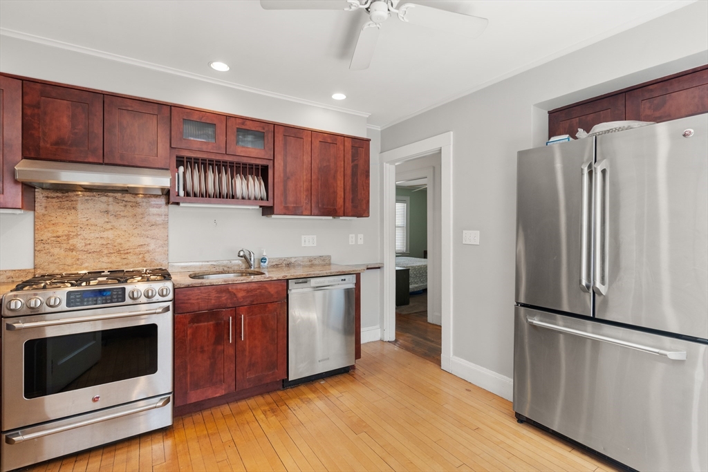 9 Searle Avenue Brookline, MA 02445 - Photo 6 of 35 a kitchen with stainless steel appliances granite countertop a refrigerator stove and wooden cabinets