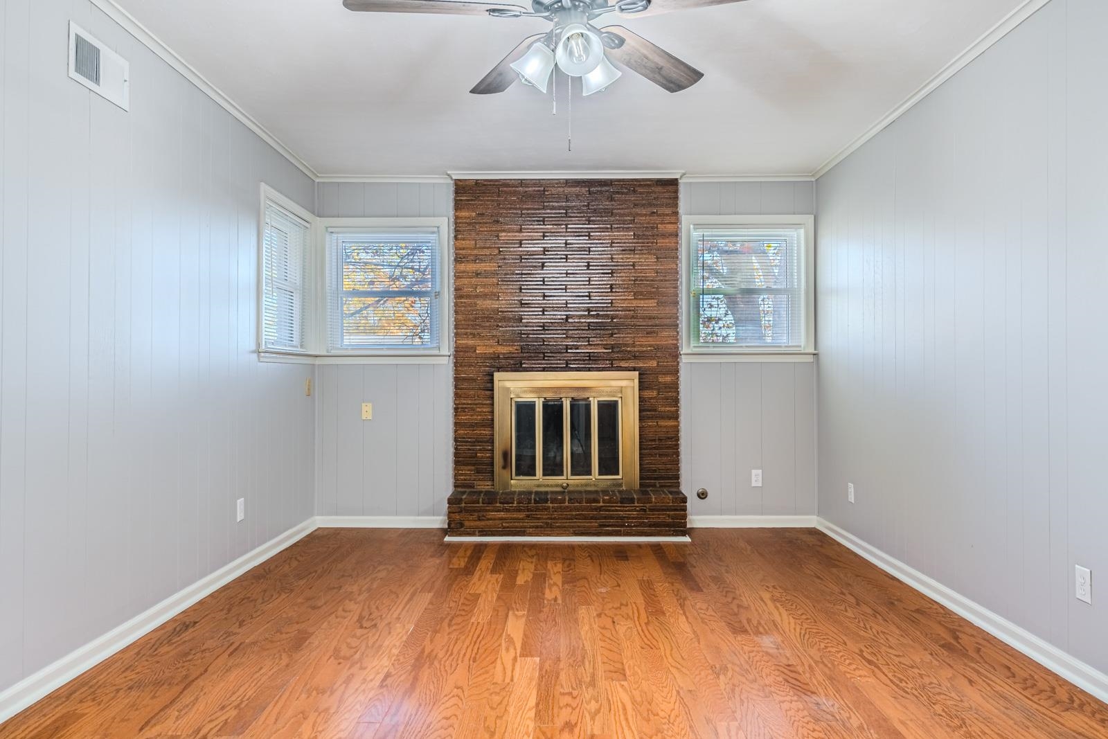 4202 Ambrose Road Memphis, TN 38116 - Photo 11 of 28 an empty room with wooden floor a ceiling fan and windows