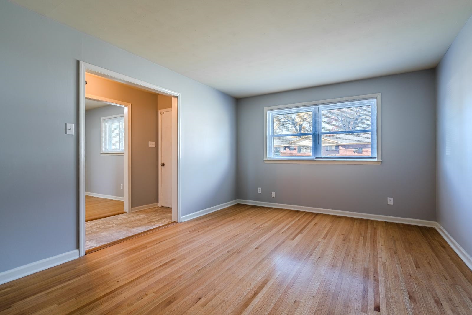 4202 Ambrose Road Memphis, TN 38116 - Photo 8 of 28 an empty room with wooden floor and windows
