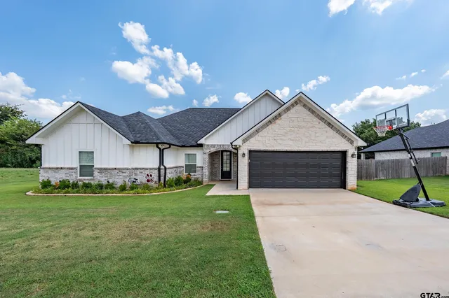 a view of a house with a yard and garage