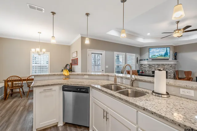 a kitchen with stainless steel appliances granite countertop a sink a stove and a wooden floors