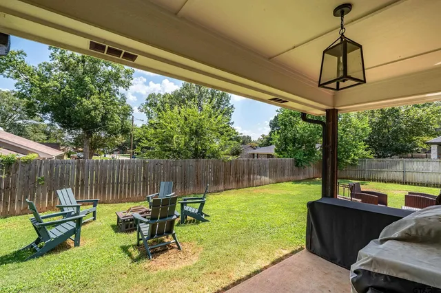 a view of a backyard with furniture and a garden