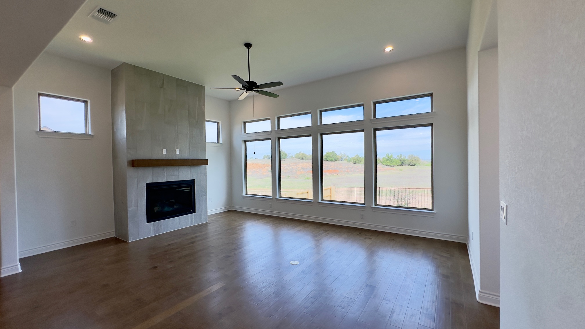 150 Firethorn Loop Bastrop, TX 78602 - Photo 19 of 39 a view of an empty room with wooden floor fireplace and a window