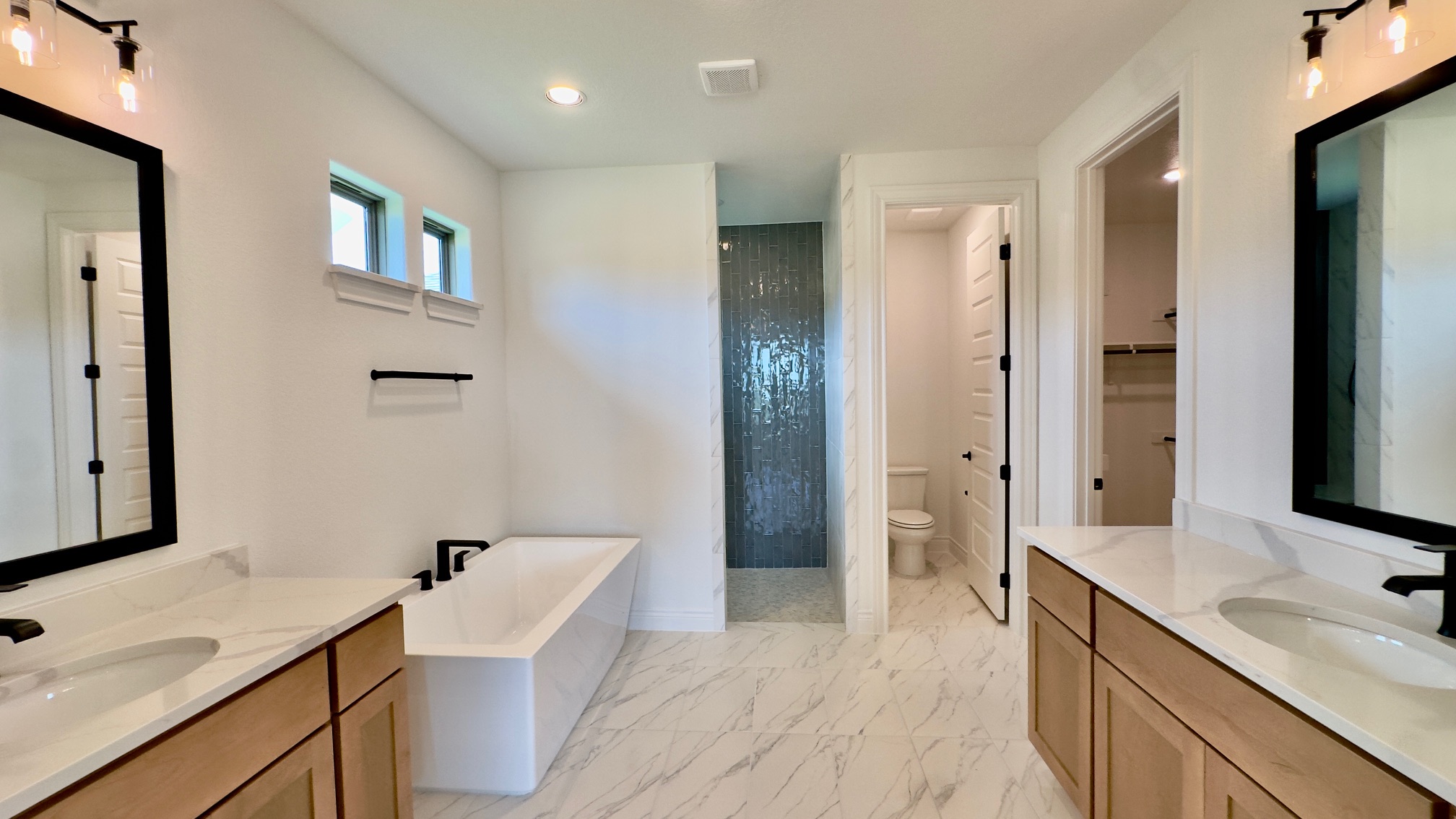 150 Firethorn Loop Bastrop, TX 78602 - Photo 23 of 39 a spacious bathroom with a double vanity sink a mirror and a shower
