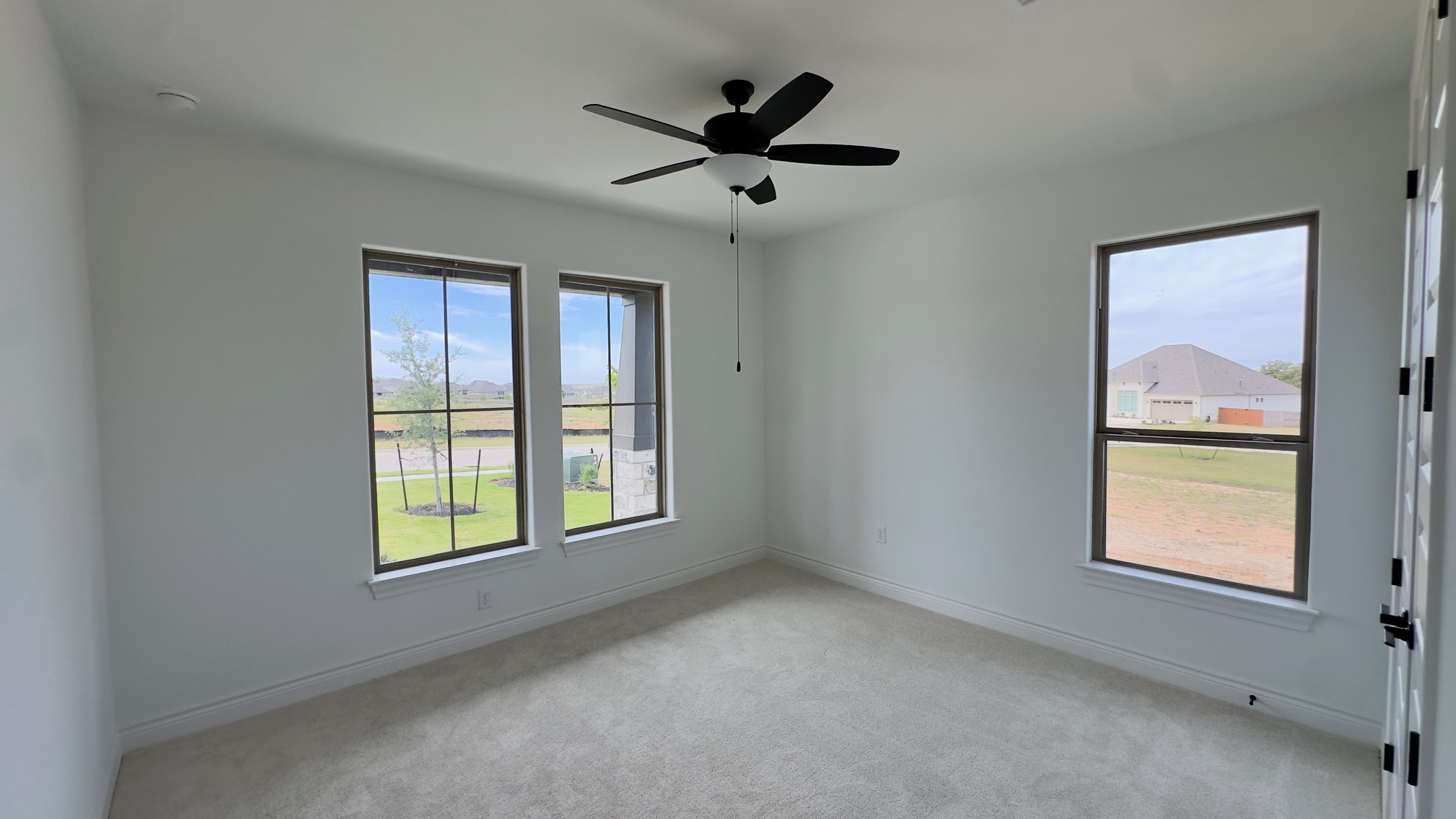 150 Firethorn Loop Bastrop, TX 78602 - Photo 7 of 39 an empty room with windows and ceiling fan