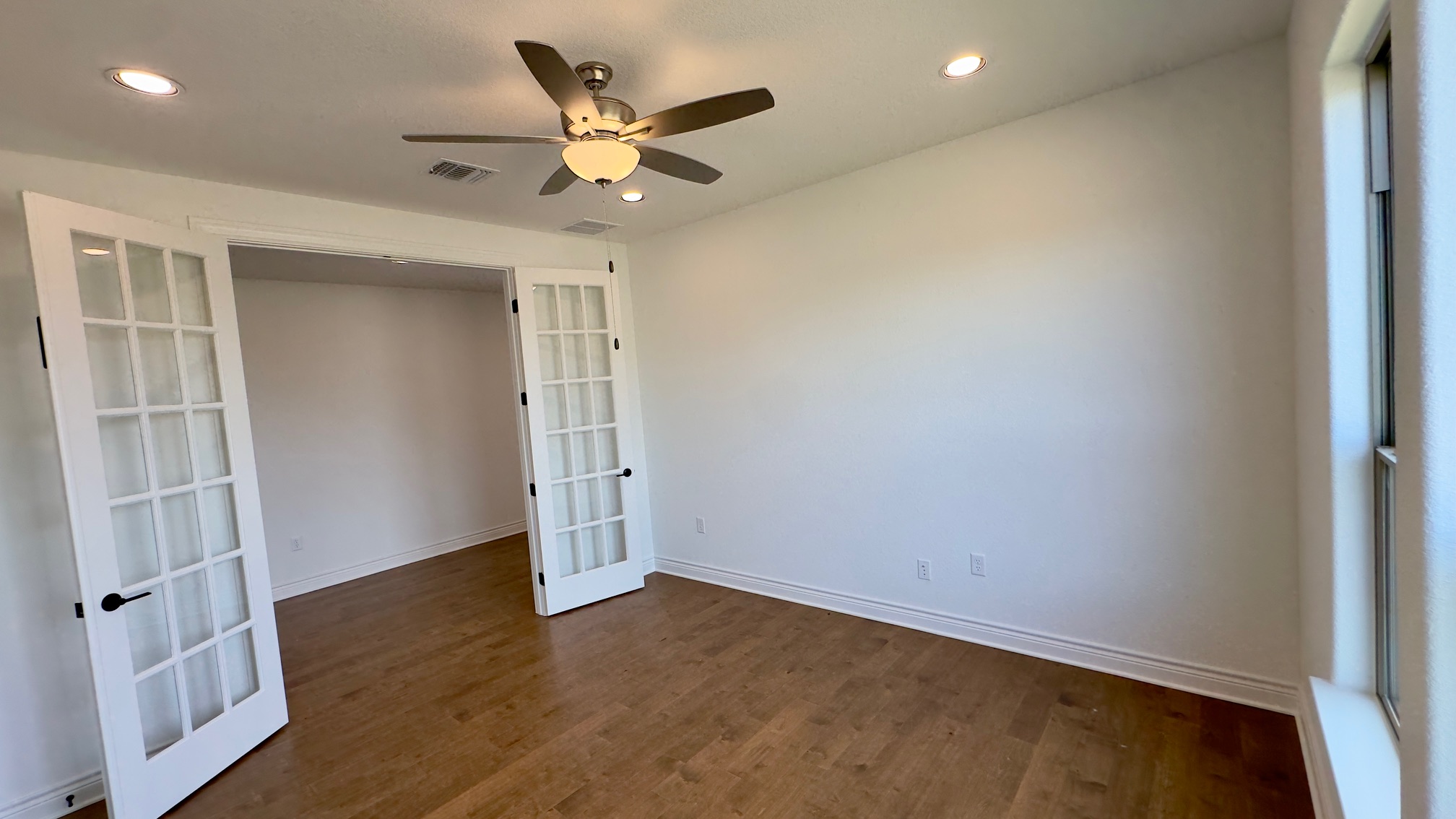 150 Firethorn Loop Bastrop, TX 78602 - Photo 10 of 39 an empty room with wooden floor and fan