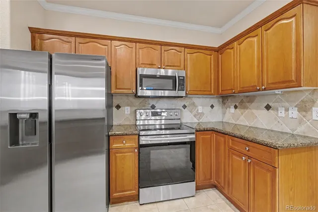 a kitchen with granite countertop stainless steel appliances sink stove and cabinets