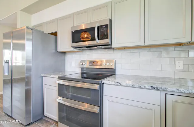 a kitchen with a counter space a sink appliances and cabinets
