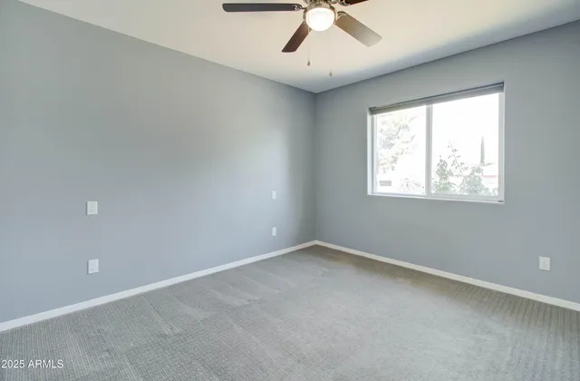 an empty room with chandelier fan