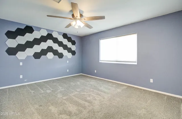 an empty room with a ceiling fan and a window
